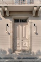 Dos puertas con un dintel decorativo y un pequeño ventanal encima.
