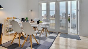 A modern dining area with a round table, white chairs, and a view through large glass doors. - "Tofan" - 100m to the fjord by Interhome (Vestervig)