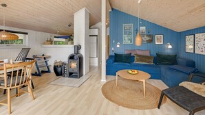 Un salon chaleureux avec un mur bleu, un canapé, une table basse et une cheminée.