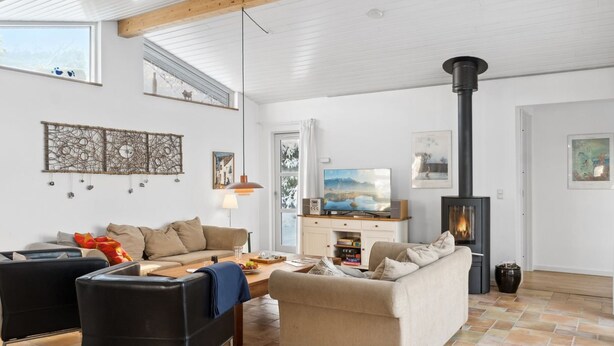 Un salón comedor amplio con techo alto, chimenea y televisor.