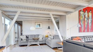 A modern living room with a grey sofa, a glass coffee table, and a wooden floor. - "Rauli" - 50m from the sea by Interhome (Saltum)