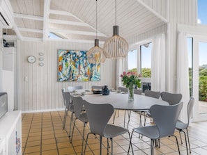 A modern dining area with a large table, grey chairs, and a painting on the wall. - "Rauli" - 50m from the sea by Interhome (Saltum)
