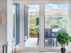 A room with a sliding glass door leading to an outdoor deck with a table and chairs.
