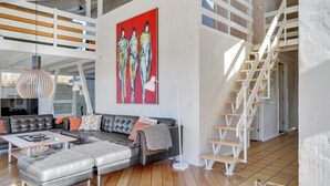 A spacious living area with a sectional sofa, a large abstract painting, and a staircase. - "Rauli" - 50m from the sea by Interhome (Saltum)
