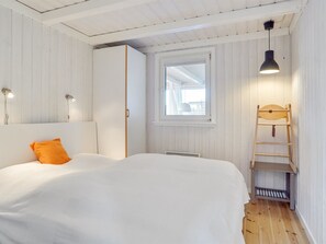 A bedroom with a bed, a wardrobe, a window, a ladder, and a pendant light. - "Rauli" - 50m from the sea by Interhome (Saltum)