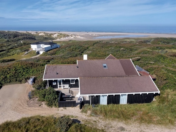 A coastal house with a sloped roof, a small porch, and a view of the beach. - "Rauli" - 50m from the sea by Interhome (Saltum)