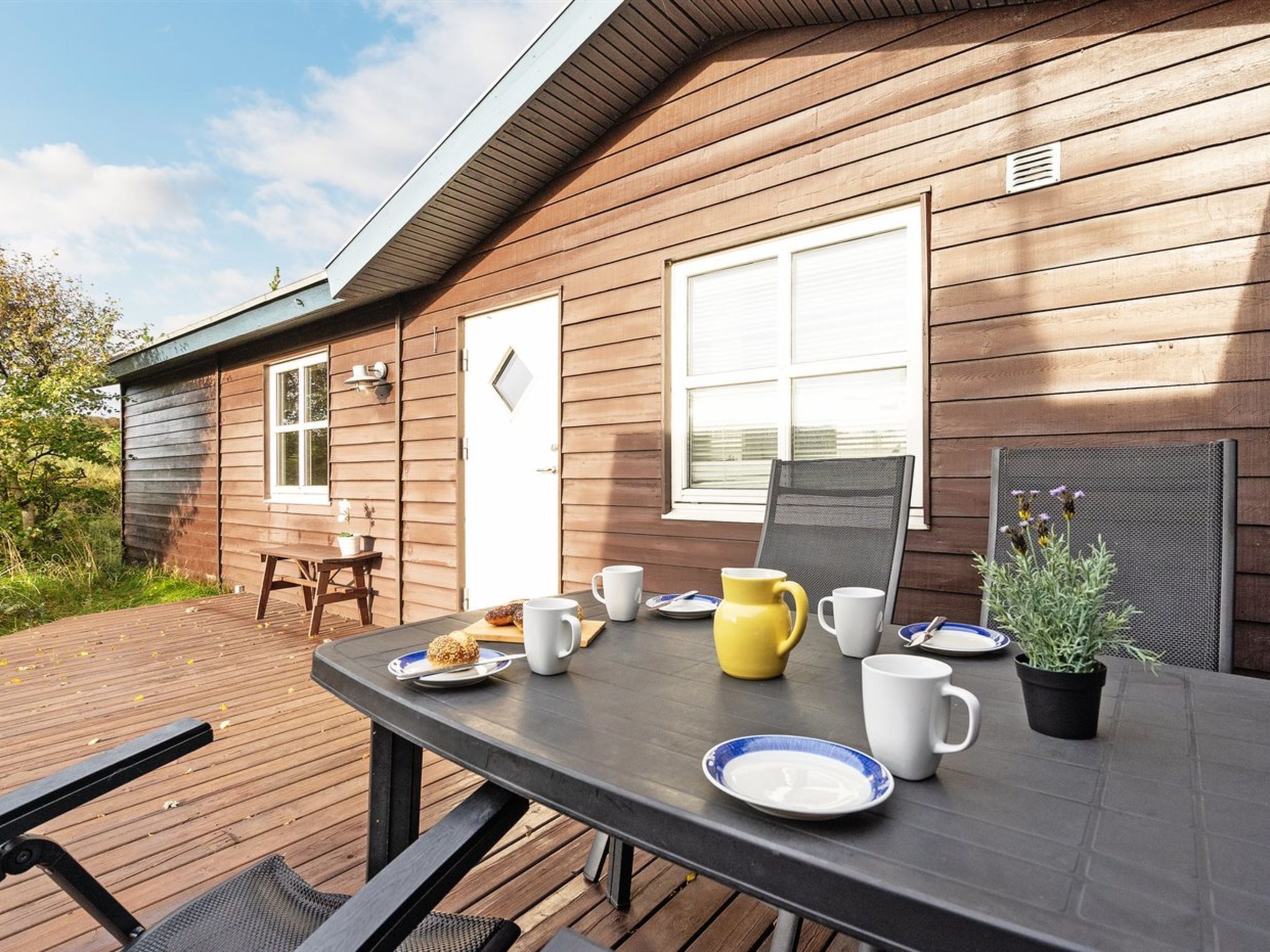 A wooden cabin with a dining table set for breakfast.