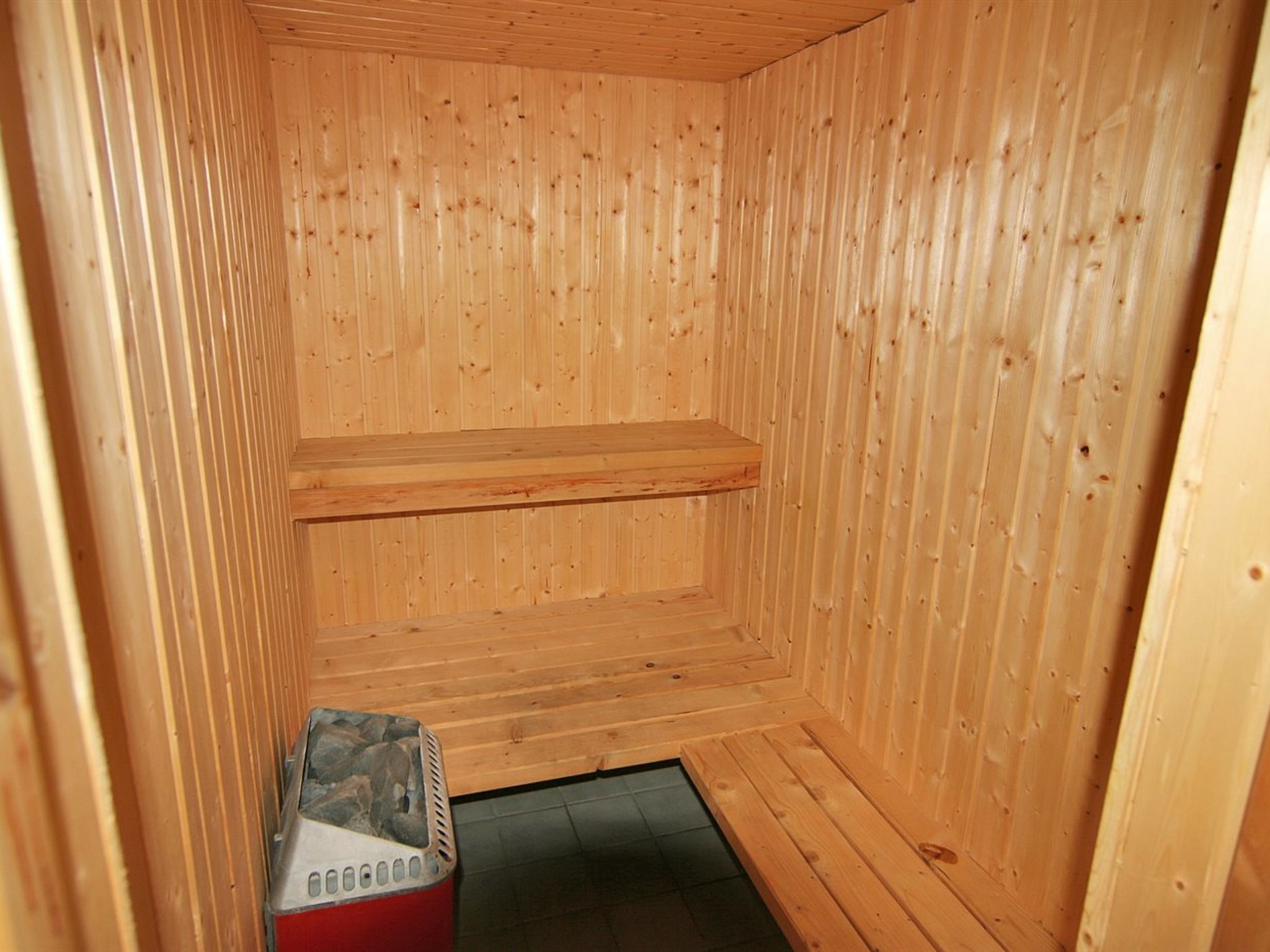 A sauna with wooden walls and a bench.