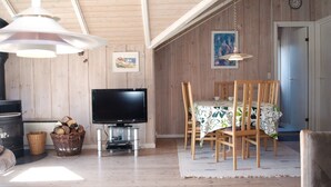 Una sala de estar acogedora con televisor, muebles de madera y chimenea.
