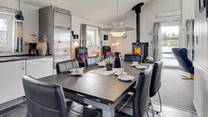 Una cocina moderna con comedor, chimenea y vistas al exterior.