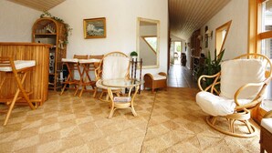 Une pièce chaleureuse avec un plafond haut, des meubles en bois et un grand miroir.