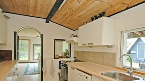 Une cuisine avec des meubles de rangement en bois, un lave-vaisselle et un évier.