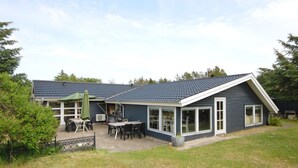 Une maison à deux étages dotée d’un patio couvert et d’une cour clôturée.