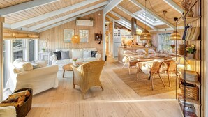 A spacious loft with high ceilings, a dining area, a living room with a sofa and chairs, and a kitchen area. - "Berenice" - 250m from the sea by Interhome (Hals)