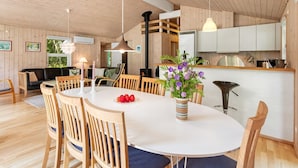 Un espace de vie moderne, à aire ouverte, comprenant un coin repas, une cuisine et un coin salon.