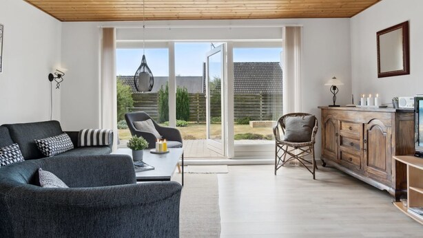 A modern living room with a sofa, armchairs, and a dining area with a wooden cabinet and a television. - "Onni" - 1km from the sea by Interhome (Væggerløse)