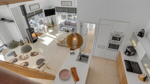 A modern kitchen with white cabinets, a built-in oven, and a coffee machine. - "Biorn" - 70m from the sea by Interhome (Otterup)
