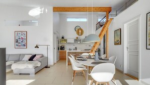 A modern living space with a dining area, kitchen, and a staircase leading to an upper level. - "Biorn" - 70m from the sea by Interhome (Otterup)