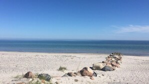 A sandy beach with a row of rocks leading to the water. - "Biorn" - 70m from the sea by Interhome (Otterup)