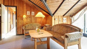 A cozy room with wooden walls and ceiling, a sofa, a coffee table with fruit, and a lamp. - "Ingwin" - 250m to the fjord by Interhome (Skjern)