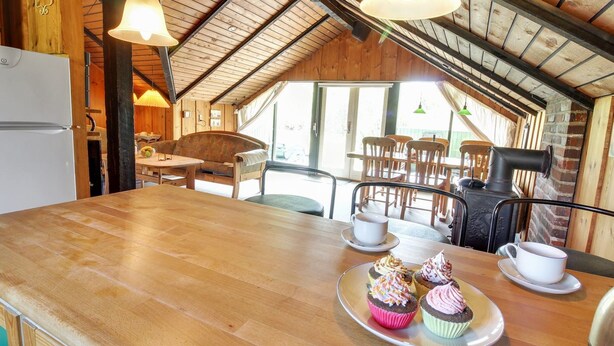 A cozy kitchen with wooden beams, a dining area with chairs, and a view through large windows. - "Ingwin" - 250m to the fjord by Interhome (Skjern)