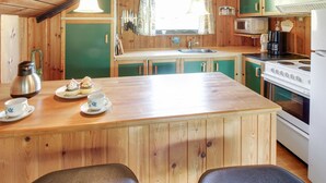 A cozy kitchen with wooden cabinets, a central island with a sink, and a stove. - "Ingwin" - 250m to the fjord by Interhome (Skjern)