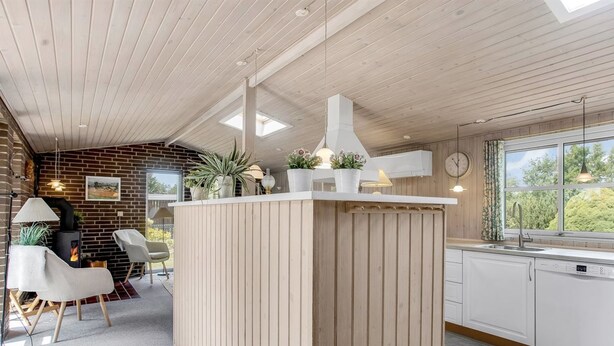 A modern kitchen with a central island, a brick wall, and a large window. - "Sessa" - 800m from the sea by Interhome (Væggerløse)