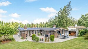 A two-story house with a covered patio, a fire pit, and a garage with firewood. - "Sessa" - 800m from the sea by Interhome (Væggerløse)