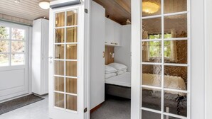 A room with a large sliding glass door, a bed with white bedding, and a wooden ceiling. - "Sessa" - 800m from the sea by Interhome (Væggerløse)