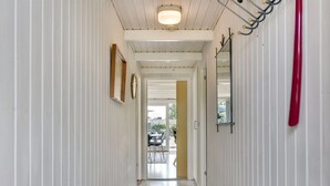 A narrow hallway with white paneling, a gray carpet, and a door leading to an outdoor area. - "Herbert" - 1km from the sea by Interhome (Humble)