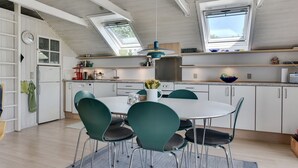 A modern kitchen with skylights, a dining area with green chairs, and white cabinetry. - "Herbert" - 1km from the sea by Interhome (Humble)