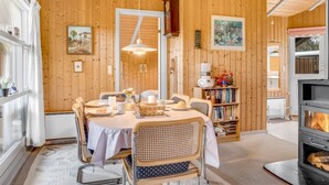Ein gemütliches Holzinterieur mit Essbereich, Bücherregalen und Kamin.