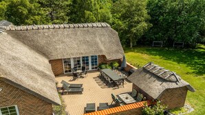 A house with a thatched roof, a patio with outdoor furniture, and a brick exterior. - "Taralyn" - 1.3km from the sea by Interhome (Væggerløse)