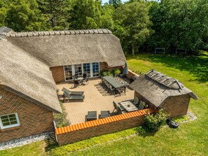 A house with a thatched roof, a patio with outdoor furniture, and a brick exterior. - "Taralyn" - 1.3km from the sea by Interhome (Væggerløse)