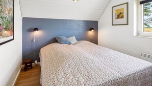 A bedroom with a bed, two wall-mounted lamps, a small stool, and a window with a view. - "Taralyn" - 1.3km from the sea by Interhome (Væggerløse)