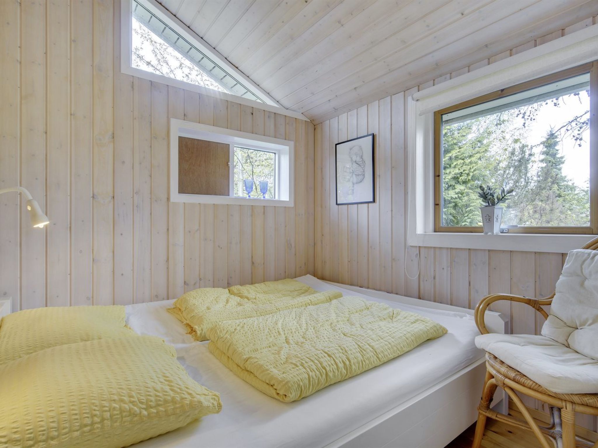A cozy room with a bed, a window, and a chair.