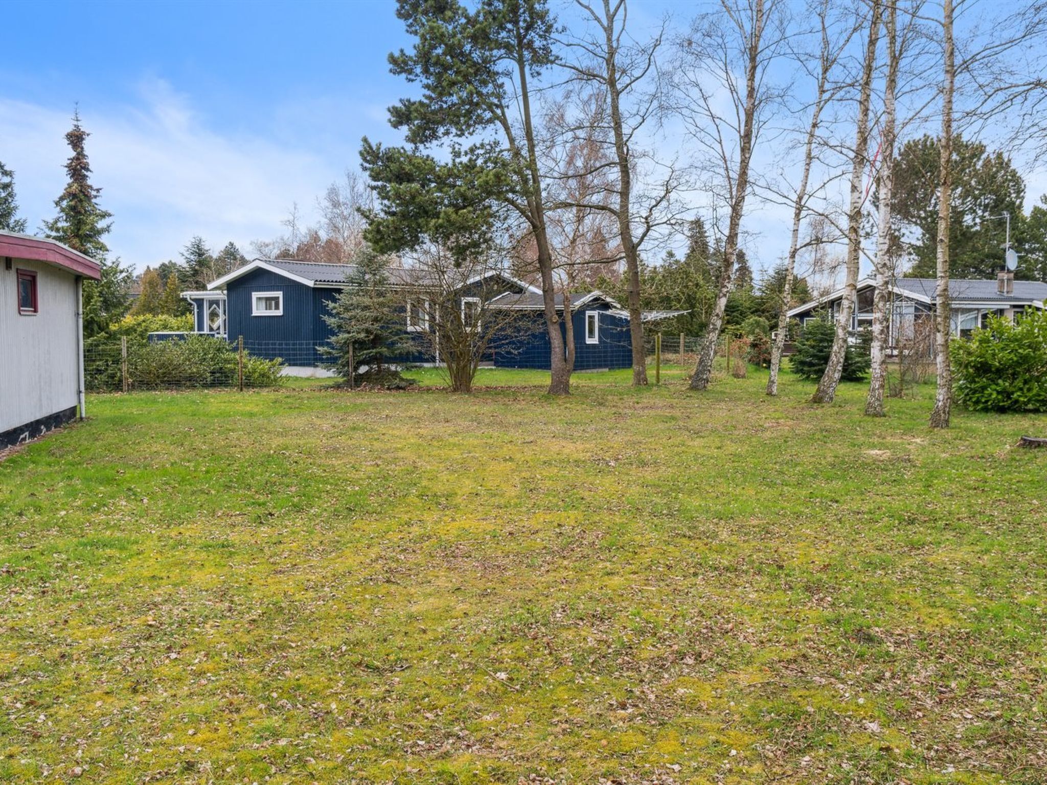 A residential area with a house, a shed, and a fenced yard.