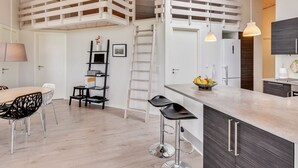 A modern kitchen with a central island, a lofted seating area, and a dining space with a table and chairs. - "Luzia" - 1.2km from the sea by Interhome (Ringkøbing)