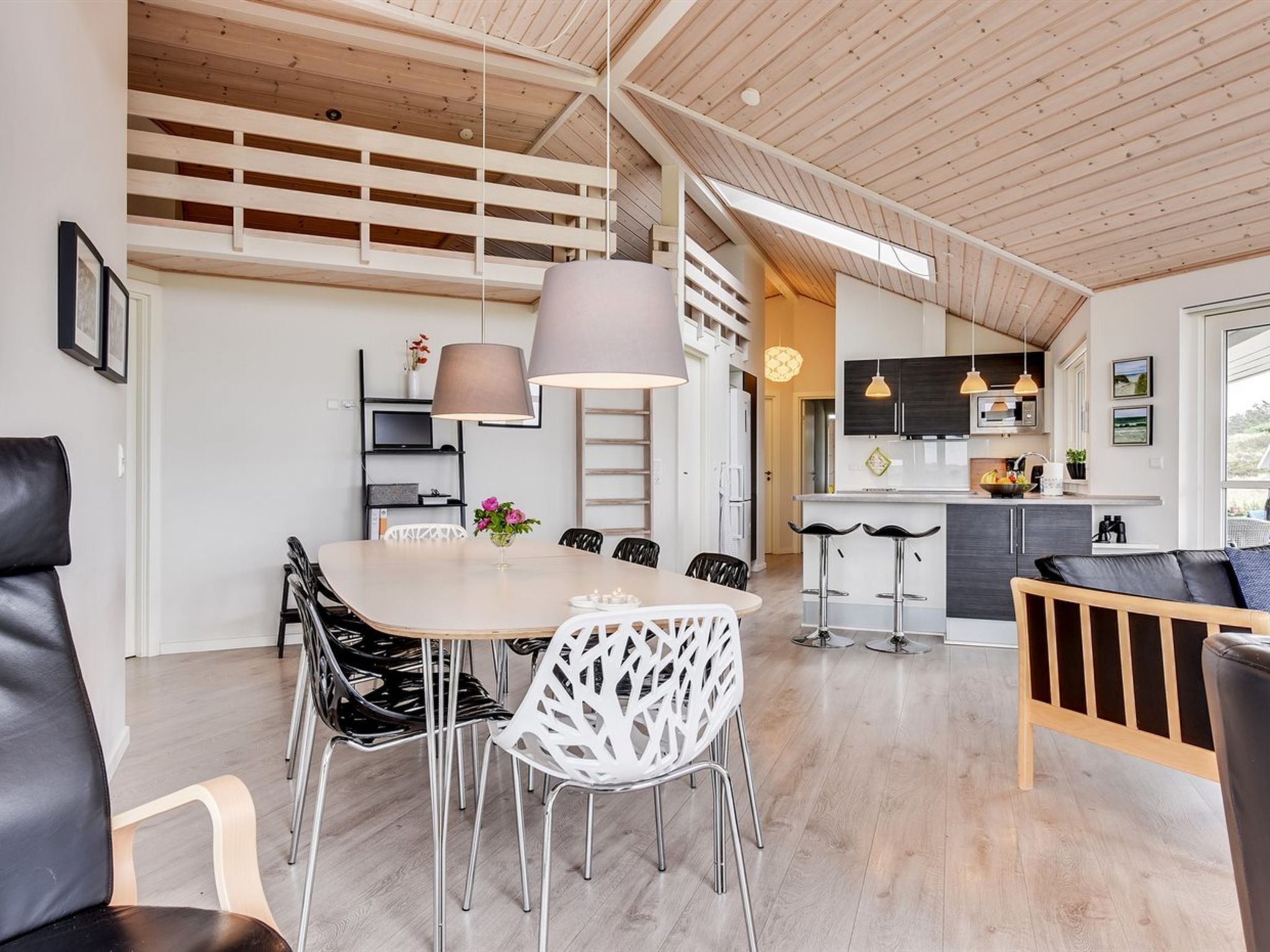 Un intérieur moderne comprenant un coin repas, une cuisine et un espace salon.
