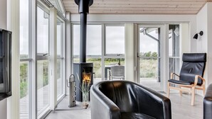 A modern interior with a fireplace, large windows, and a view of the outdoors. - "Luzia" - 1.2km from the sea by Interhome (Ringkøbing)