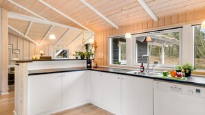 A modern kitchen with wooden beams, white cabinets, and a large window. - "Abiorn" - 2.5km from the sea by Interhome (Blåvand)