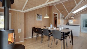 Eine moderne Küche mit Holzwänden, einer zentralen Kochinsel und einem eingebauten Holzofen.
