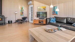 A cozy living room with a fireplace, a sofa, a coffee table, and a TV. - "Enid" - 700m from the sea by Interhome (Væggerløse)