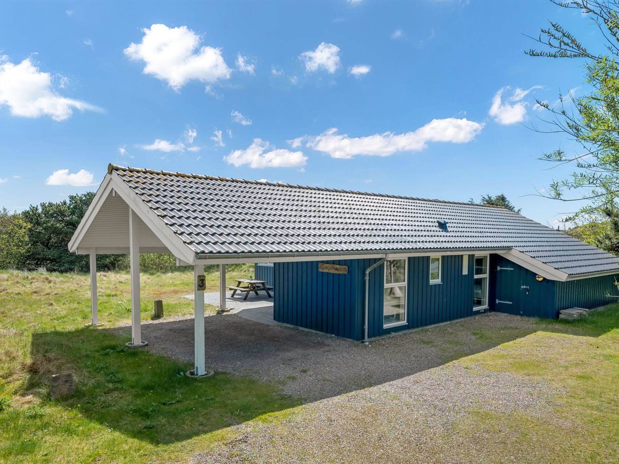 A small, single-story building with a pitched roof and a covered patio area.