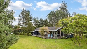A house with a covered porch, a fenced yard, and surrounding trees. - "Fatlinda" - 1km from the sea by Interhome (Væggerløse)