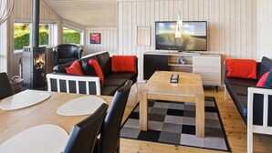 Un salon chaleureux avec une cheminée, des sièges confortables, un téléviseur et un coin repas.