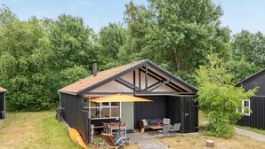 A small house with a covered patio, a dining area, and a kayak. - "Robert" - 250m from the sea by Interhome (Væggerløse)