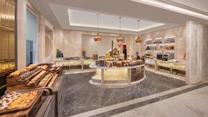 Ein luxuriöses Buffet mit Marmorboden, einer zentralen Servicestation und unterschiedlichen Speisenpräsentationen.