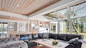 A spacious living area with a leather sofa, a wooden coffee table, and a dining area with a table and chairs. - "Gertrudis" - 2km to the fjord by Interhome (Frøstrup)