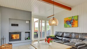 A modern living room with a fireplace, a sofa, a coffee table, and a painting on the wall.
